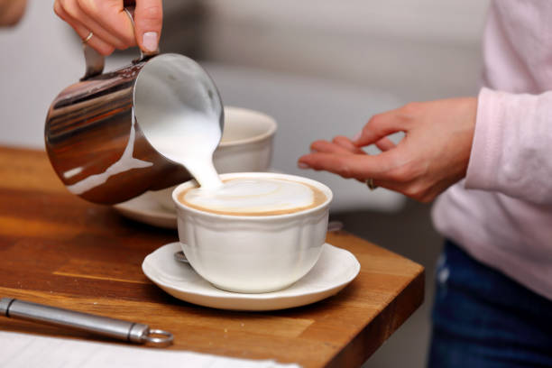 istock Young woman making cappuccino 668443238