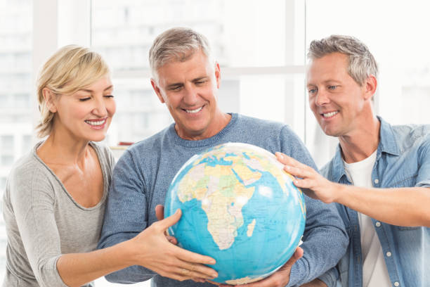 istock Happy business colleagues holding terrestrial globe 668446322