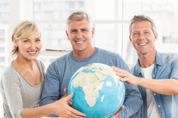istock Happy business colleagues holding terrestrial globe 668446360