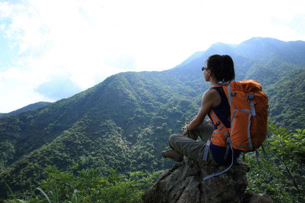 istock successful young woman hiker hiking on mountain peak 668456086