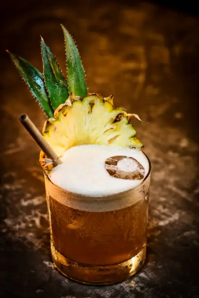 Photo of pineapple mango tropical rum fruity cocktail drink in bar