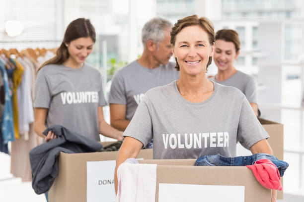 istock Smiling female volunteer carrying donation box 668465478