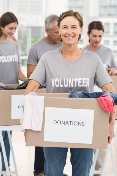 istock Smiling female volunteer carrying donation box 668465558
