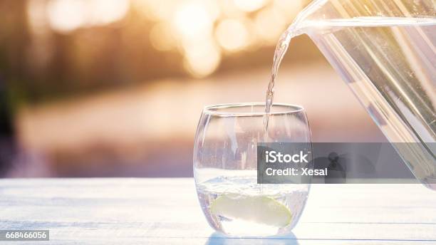 Pouring Water From Pitcher Into Glass Stock Photo - Download Image Now - Water, Drinking Glass, Pouring