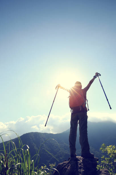 istock successful young woman hiker open arms on mountain peak 668469830