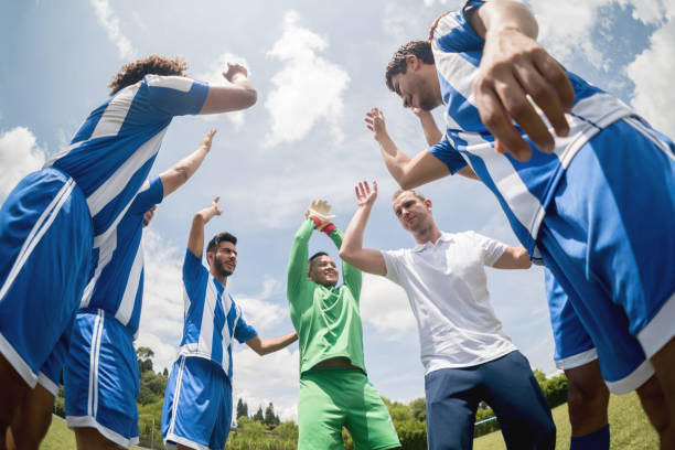 istock Happy football team with their coach 668472450