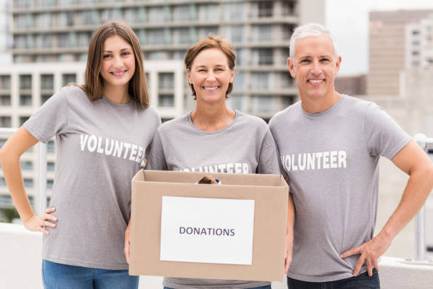 istock Smiling volunteers holding donation box 668477594