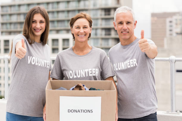 istock Smiling volunteers with donation box doing thumbs up 668477612