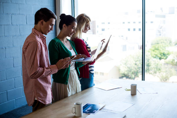 istock Colleagues using mobile phone, digital tablet and laptop at their desk 668480692