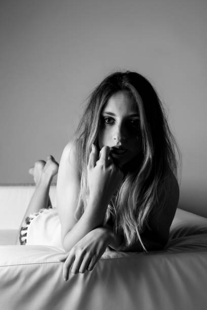 istock Shy girl lying alone on a white couch, dreaming. 668484004
