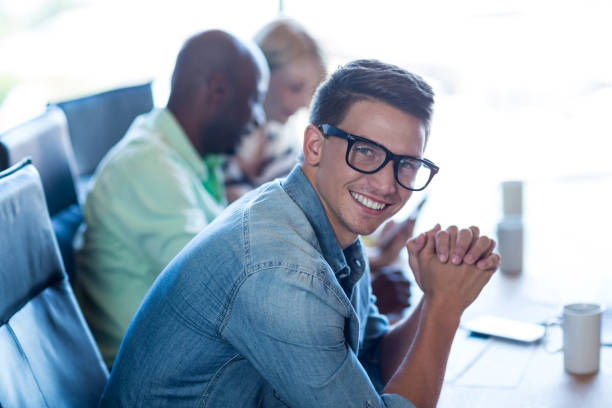 istock Young man sitting at his desk smiling at camera 668490664