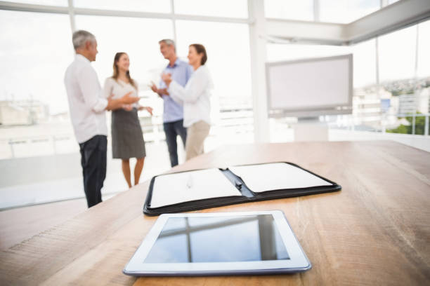 istock Tablet and planner in front of talking business people 668506120