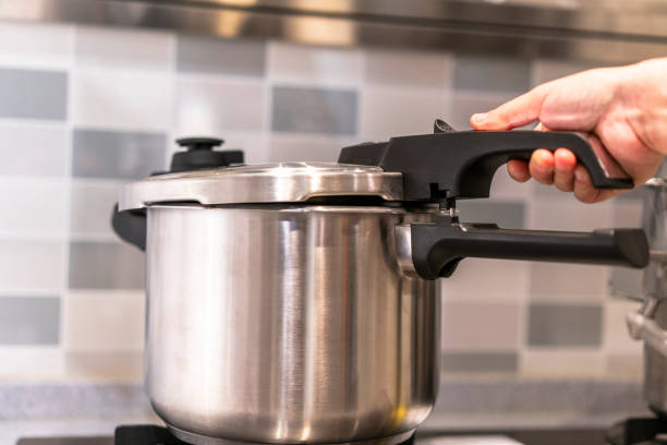 using pressure cooker in kitchen stock photo