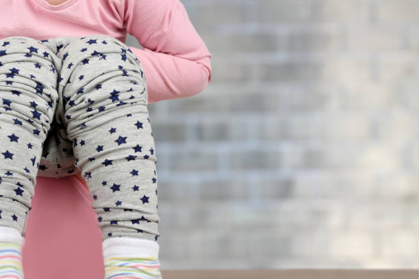 children's legs hanging down from a chamber-pot on a blue background - one baby girl only fotos imagens e fotografias de stock