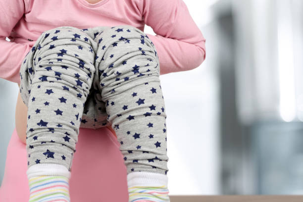 istock Children's legs hanging down from a chamber-pot on a blue background 668515982
