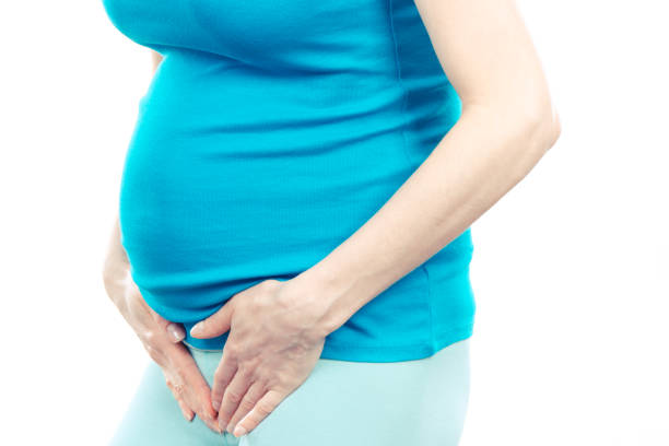 Pregnant woman with hands on her stomach, pregnancy health care and bladder aches stock photo