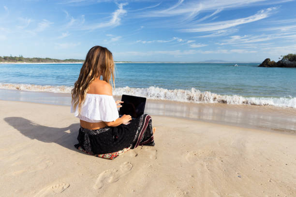 Girl Working on Laptop at the Beach stock photo