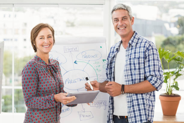 istock Smiling casual business colleagues with tablet 668519796