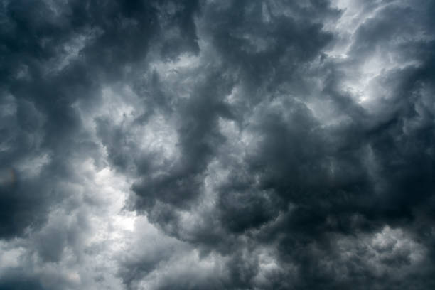 istock Background of dark clouds before a thunder-storm ,sunlight through very dark clouds background ,White Hole in the Whirlwind of dark storm clouds 668519994