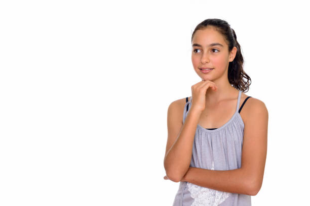 Studio shot of young beautiful teenage girl looking away while thinking isolated against white background