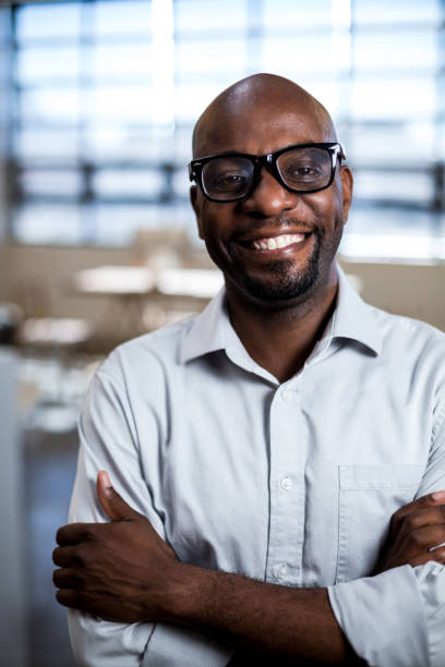 istock Man with arms crossed smiling at camera 668523126