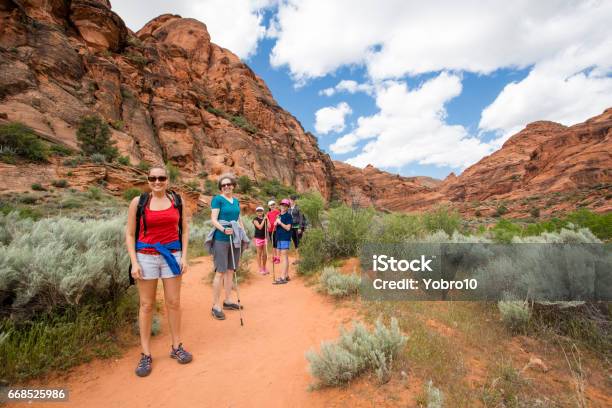 Group Of People Hiking In The Beautiful Desert Cliffs In Usa Stock Photo - Download Image Now