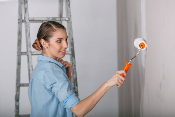 istock Beautiful young woman doing wall painting 668533162