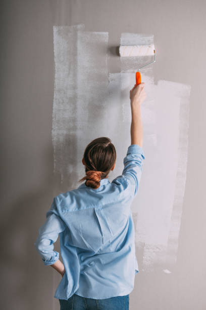 istock Beautiful young woman doing wall painting 668533370