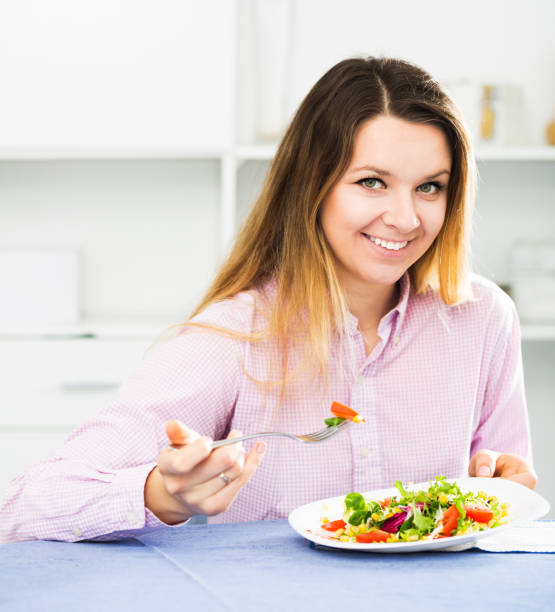 istock Girl eating green salad 668536380