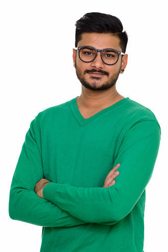 Young handsome Indian man wearing eyeglasses with arms crossed vertical shot