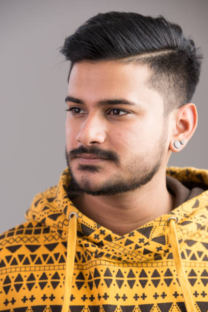 istock Face of young handsome Indian man thinking while looking away 668540960