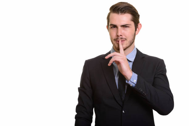 istock Young handsome businessman with finger on lips 668551768