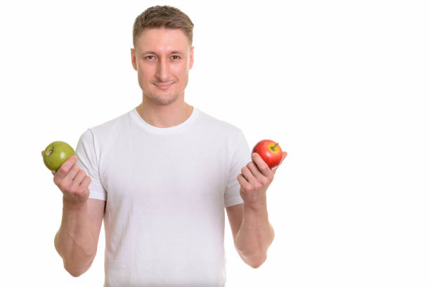 istock Handsome man holding green apple and red apple ready for gym 668557874