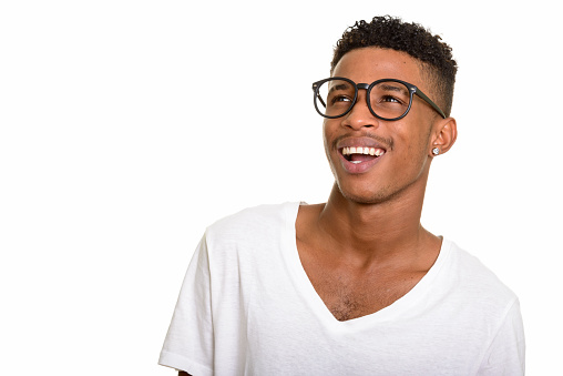Young happy African man smiling while thinking and wearing eyeglasses horizontal shot