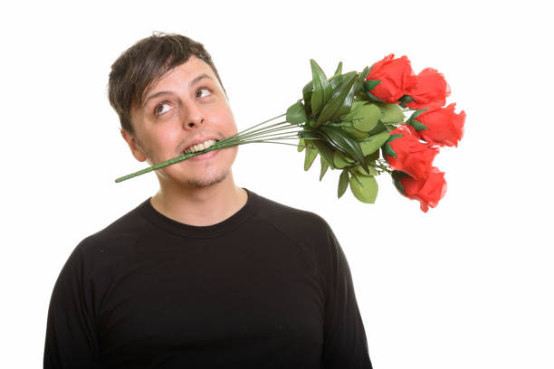 istock Studio shot of crazy man biting red roses and thinking ready for Valentine's day 668569068