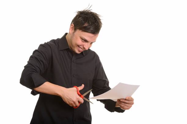 istock Studio shot of happy crazy businessman smiling while cutting paper 668569124