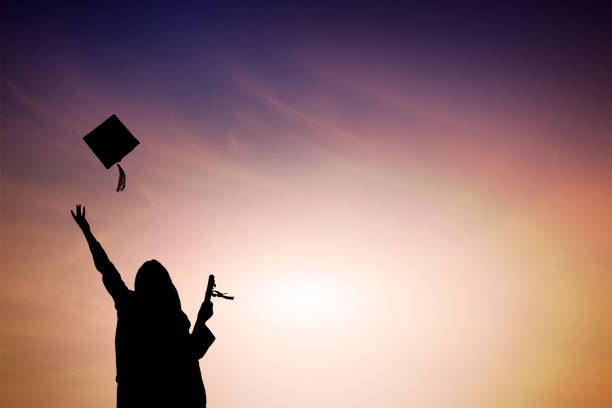 istock Graduate students tossing up hats over blue sky 668569266