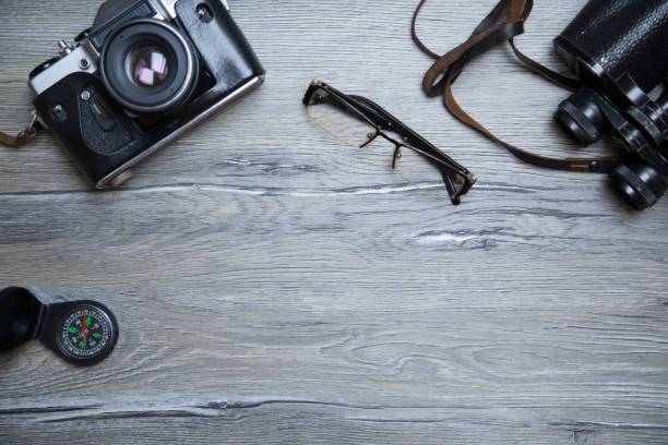 istock Travel - binoculars and retro camera on vintage table. 668569516