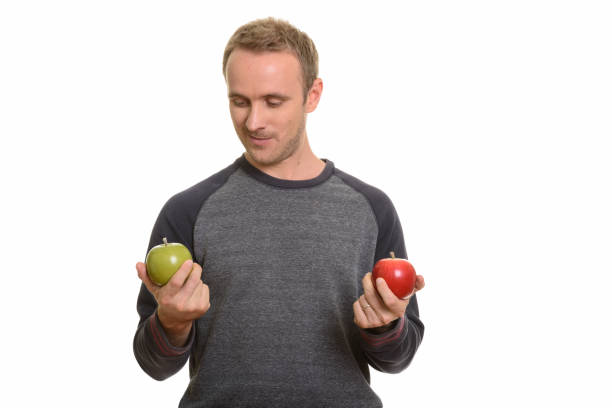 istock Handsome man choosing between red apple and green apple 668572260