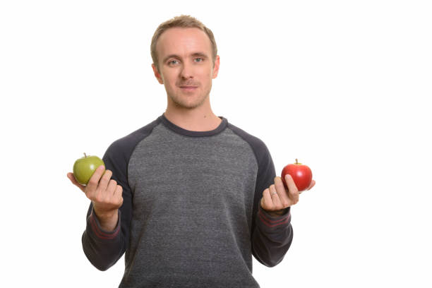 istock Handsome man holding red apple and green apple 668572282