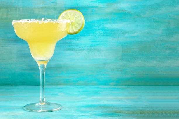 Lemon Margarita cocktails on vibrant turquoise with copyspace Lemon Margarita cocktail with a wedge of lime on a vibrant turquoise background with copy space tequila drink photos stock pictures, royalty-free photos & images