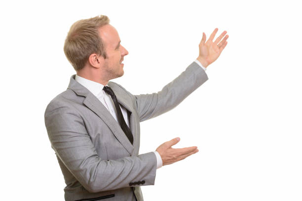 istock Profile view of handsome businessman showing something 668572560