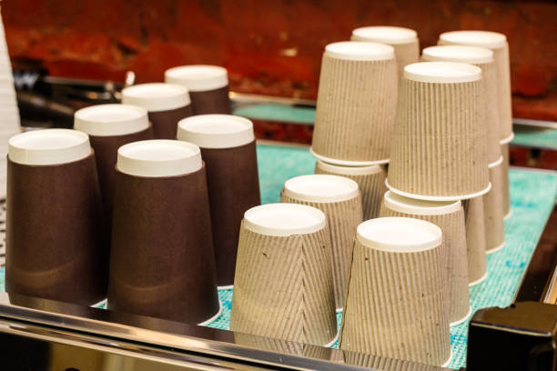 istock A coffee machine with a large stack of paper cups next to it. 668575648