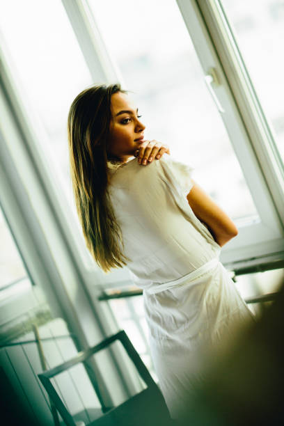 istock Young woman standing by the windows 668578352