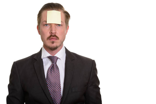 istock Young handsome businessman with sticky note on forehead 668578402