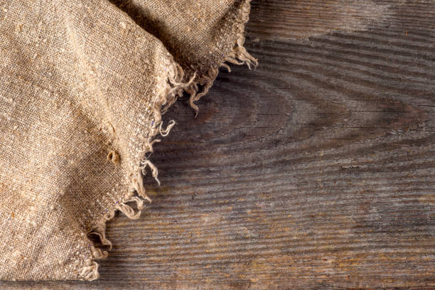 istock burlap hessian sacking on wooden background 668585908