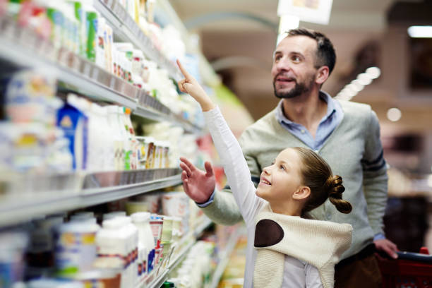 указывая на молочный продукт - supermarket shopping retail choice стоковые фото и изображения