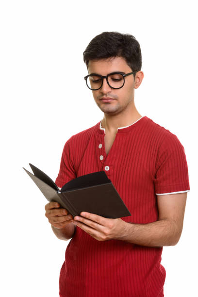 istock Young handsome Persian man reading book while wearing eyeglasses 668596154