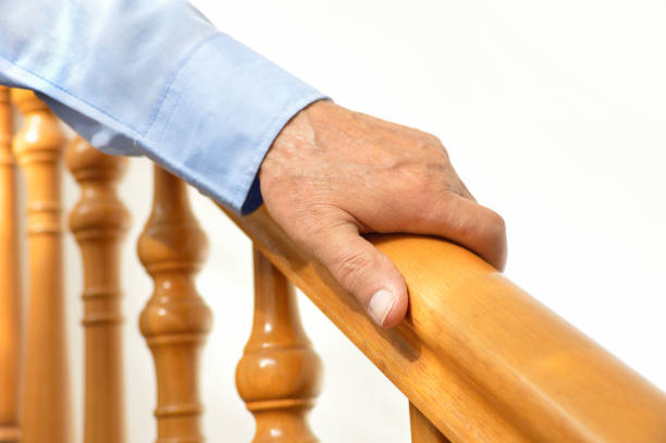 istock hand of senior man over a wooden railing 668596248