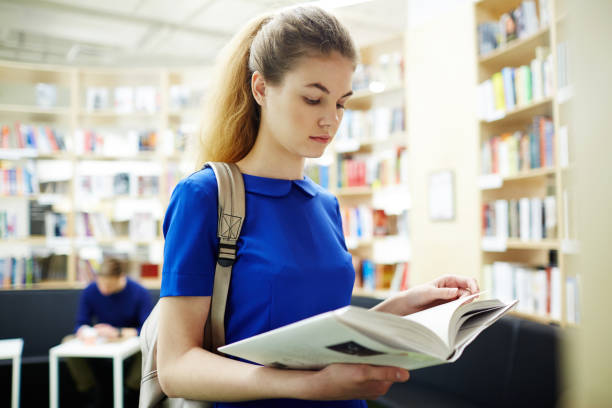 istock Beautiful Girl Preparing for Exams in Library 668596434